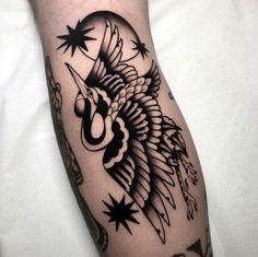 a black and white photo of a tattoo on someone's leg with stars around it