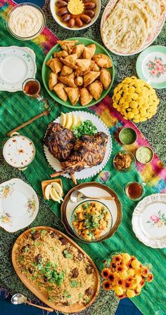 a table filled with different types of food on plates and bowls next to each other