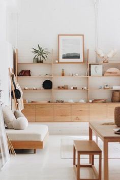 a living room filled with lots of furniture next to a wall mounted shelf covered in pictures