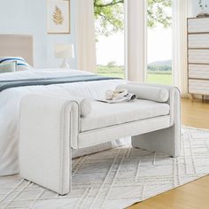 a white bed sitting on top of a wooden floor