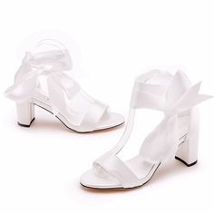 a pair of white high heeled shoes with a bow on the front and side