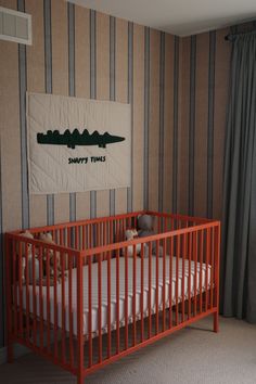 a baby crib in a room with striped walls