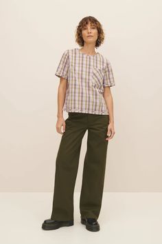 An elevated everyday top, made from 100% certified Fairtrade organic cotton poplin shirting in a joyful woven check. The Adrian Top has a standard fit with bust darts for gentle shaping and side splits for ease of wear. It features a binding detail at the cuffs and hem, and fastens with a button and loop at the back. This garment is completely plastic-free. Sizing: This style is true to size. We recommend taking your normal size. Plaid Cotton Tops For Daywear, Plaid Short Sleeve Tops For Work, Relaxed Fit Cotton Tops For Workwear, Plaid Cotton Work Tops, Green Cotton Tops For Workwear, Green Cotton Workwear Tops, Green Cotton Tops For Casual Gatherings, Green Cotton Tops For Daywear, Pink Tartan