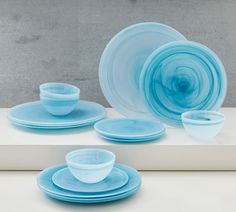 blue dishes and cups sitting on top of a white countertop next to each other