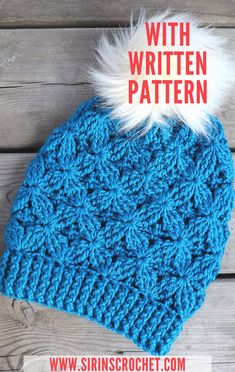 a blue crocheted hat with white fur pom