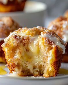 a close up of a muffin on a plate with some other muffins in the background