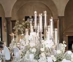 the table is set with white flowers and candles for an elegant wedding reception or special event