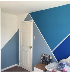 a bedroom painted in blue and white with a bed