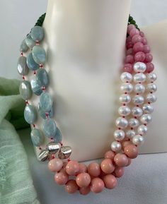 Aquamarine Jade Necklace hand knotted in red silk thread, 8 mm fresh water pearls, 1mm sterling silver cube beads,10 mm peach coral, 8 mm pink jasper, 4 mm green jade, 18 mm flat oval milky aquamarine with custom sterling silver findings and fastener. This one of a kind, triple strand necklace is 20 inches long plus 2.5 inch externder clasp, weight is 6.4 oz handcrafted in North Palm Beach, Florida by designer/ artist Christine Smith Elegant Red Coral Gemstone Beads, Elegant Hand-strung Coral Necklace, Multi-strand Pearl Necklace With Gemstone Beads, Elegant Adjustable Red Coral Beaded Necklaces, Elegant Adjustable Red Coral Beaded Necklace, Elegant Coral Gemstone Beaded Necklaces, Elegant Coral Beaded Necklaces With Gemstone, Elegant Double Strand Coral Necklace, Elegant Single Strand Coral Beads