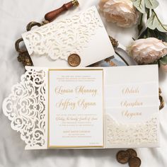 the wedding stationery is laid out on a bed with flowers and pennets next to it