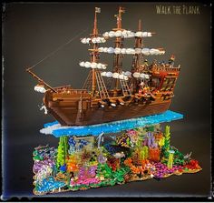 a lego model of a pirate ship in the ocean with fish and corals on display