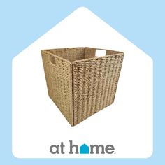 a brown wicker basket sitting on top of a blue and white sign that says at home