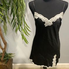 Elegance Is Key: This Beautifully Draped Slip Features Delicate Lace Trim At The Neckline. Lace Trim Adjustable Spaghetti Straps Hits Above Knees Machine Wash Imported Body: 100% Polyester Lace: 99% Polyamide, 1% Elastane Exclusive Of Decoration Fitted Black V-neck Nightgown, Black Lace Trim Camisole Slip Dress, Black Camisole Slip Dress With Lace Trim, Elegant Black Nightgown For Summer, Fitted Mini Dress With Lace Trim For Night, Chic Fitted Nightgown, Fitted Summer Night Chemise, Summer Night Fitted Chemise, Elegant Black Chemise