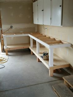 an unfinished kitchen with white cabinets and drawers