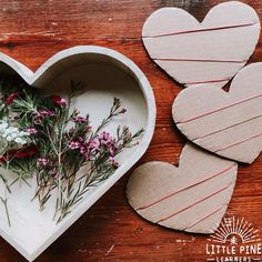 two heart shaped boxes with flowers in them