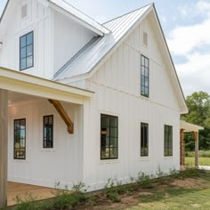 a large white house sitting on top of a lush green field