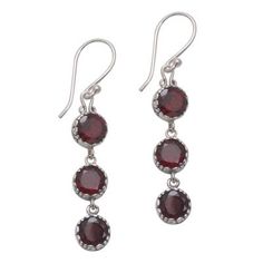 Over three carats of gorgeous faceted garnet gemstones sparkle in this lovely pair of dangle earrings presented by Komang Wijayana of Bali. He works with local artisans who craft each earring from sterling silver with a trio of round garnet stones dangling elegantly below one another in bezel settings. An oxidization technique is used to enhance the swirling motifs seen on the sides of the earrings accentuating their natural beauty. Garnet Jewelry With Matching Round Earrings, Garnet Gemstone Drop Earrings, Handmade Silver Earrings With Garnet, Garnet Earrings Silver, Silver Garnet Dangle Earrings, Faceted Garnet Drop Earrings, Garnet Faceted Drop Earrings, Ornate Silver Garnet Jewelry, Garnet Faceted Earrings For Gift