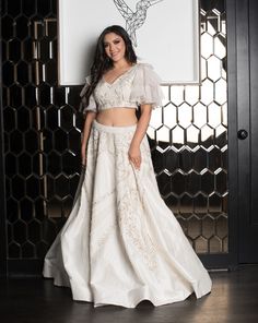 Diana is the perfect pick for the bride who wants a white wedding with a desi touch. Diana features a white lehenga with pearls, diamonds, and a touch of gold beadwork. The blouse has fun ruffled sleeves and a deep V back. Complete the look with its delicate dupatta. DELIVERY TIMEPlease allow 4-6 months for your outfit to arrive. FABRIC DETAILSRaw Silk. Professional cleaning only. Elegant Off-white Lehenga For Festive Occasions, Elegant Off-white Choli With Zari Work, Elegant Off White Choli For Festive Occasion, Elegant Off White Festive Choli, Elegant Off White Choli With Zari Work, White Raw Silk Wedding Sets, White Raw Silk Sets For Wedding, Bollywood Style Off White Sharara For Wedding, White Anarkali Set Hand Embellished