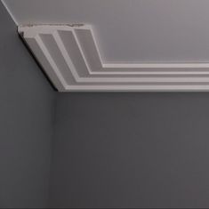 the corner of an empty room with white paint on the ceiling and some lines painted on the wall