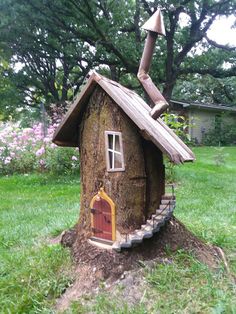 a tree stump with a house on top and stairs leading up to the door that is open