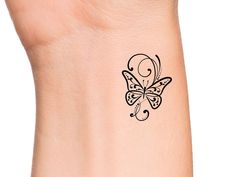 a small butterfly tattoo on the wrist