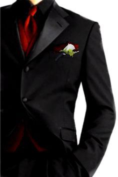 a man in a black suit with a red tie and flower on his lapel