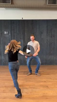 two men and a woman are dancing in an empty room with wood flooring on the walls