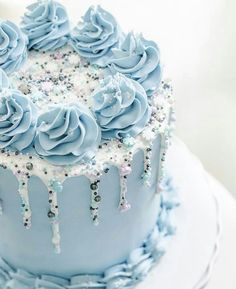 a blue frosted cake with icing and sprinkles on the top