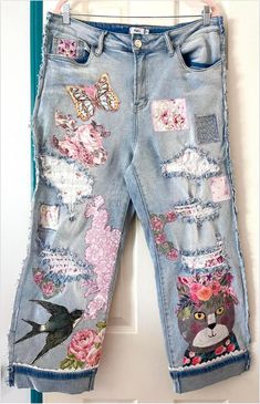 a pair of jean pants with cats and flowers on them