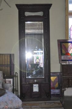 a room with stained glass windows, furniture and a large grandfather clock on the wall