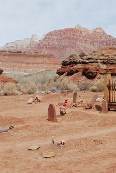 a cemetery in the middle of a desert with mountains in the backgrouds