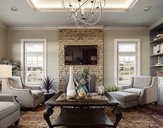 a living room filled with furniture and a stone wall