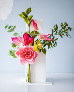 a white vase filled with flowers on top of a table