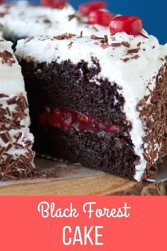 black forest cake with white frosting and cherries on top, cut in half