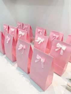 pink paper bags with white bows on them