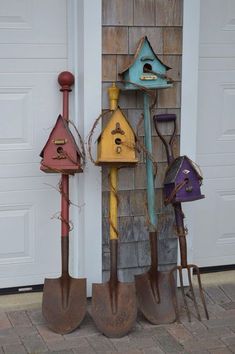 three shovels are lined up next to each other in front of a garage door