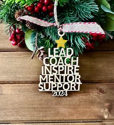 a christmas ornament with the words lead coach inspire mentor support hanging from it