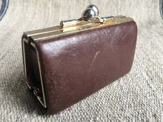 a brown purse sitting on top of a carpet covered floor next to a metal object