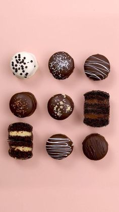 chocolates and pastries are arranged on a pink surface