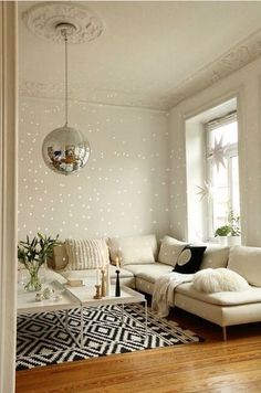 a living room with white couches and black and white rugs on the floor