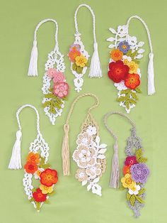 an assortment of crochet flowers and tassels are shown on a green background