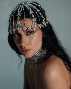 a woman wearing a tiara and pearls on her head