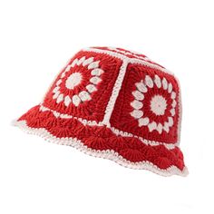 a red and white crocheted hat with flowers on it's brim