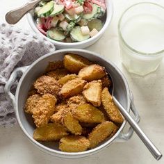 two bowls filled with food next to a glass of water