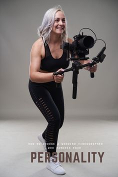 a woman is holding a camera and smiling