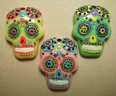 three colorful sugar skulls sitting on top of a table