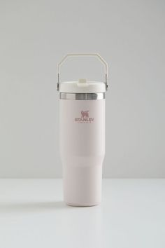 a white insulated cup sitting on top of a table