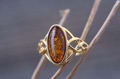 Art Gemelli present's lovely ring made of natural Baltic amber. It has been lovely set in sterling silver and covered by 14 CT gold layer. Cognac type of amber. Celtic heritage inspired design. Perfect for everyday use. Ideal gift.    Perfectly polished cognac Baltic amber set in 925 sterling silver setting and covered by 14 CT gold layer.    This ring comes with LIFETIME CRAFTWORK WARRANTY for your peace of mind. Gift wrap is also provided.    We source our amber from Baltic coast often looking Celtic Heritage, Celtic Design, Silly Goose, International Jewelry, Amber Ring, Handcrafted Art, Citrine Ring, Celtic Designs, Lovely Ring