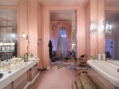 a bathroom with pink walls and flooring, chandelier, tub, sink, mirror