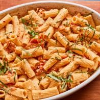 a bowl filled with pasta and garnished with herbs